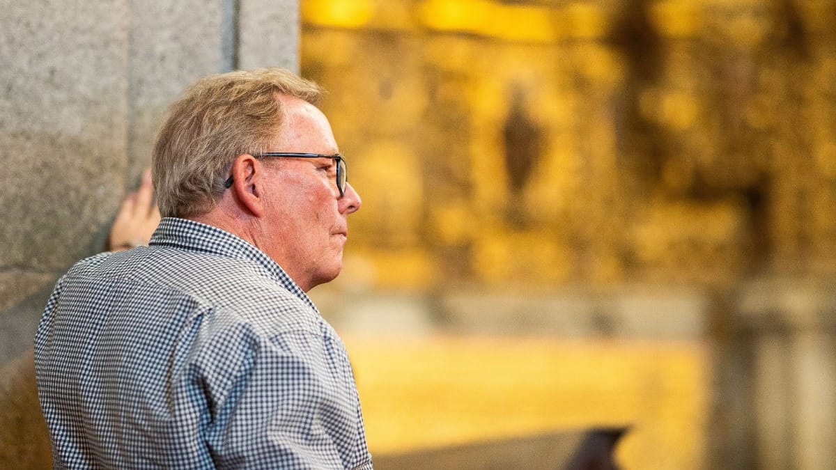 Visitor relaxing beside ancient stone walls of a historic Monastery in Porto, Portugal