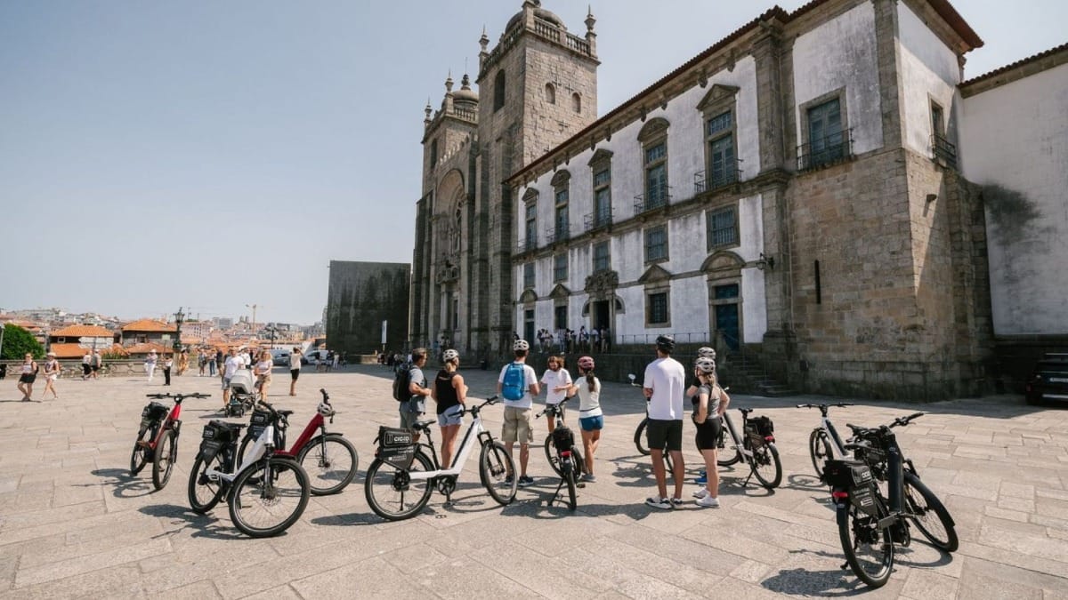 Small group on a Porto electric bike highlights and history tour stopping in front of the iconic Porto Cathedral