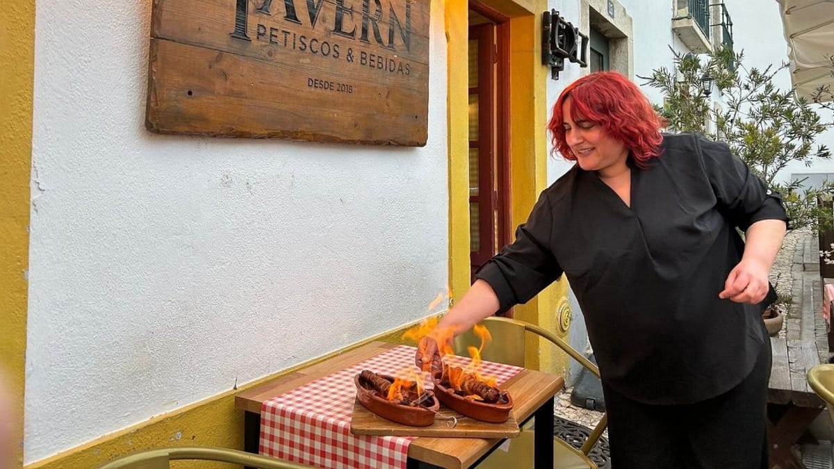 Flaming chouriço being served outdoors at a traditional tavern in Faro