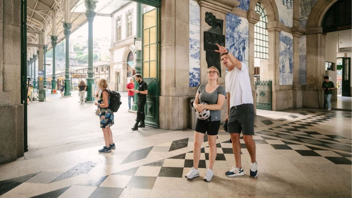 Electric bike tour in Porto making a stop at São Bento Station to admire its famous azulejo blue tile murals