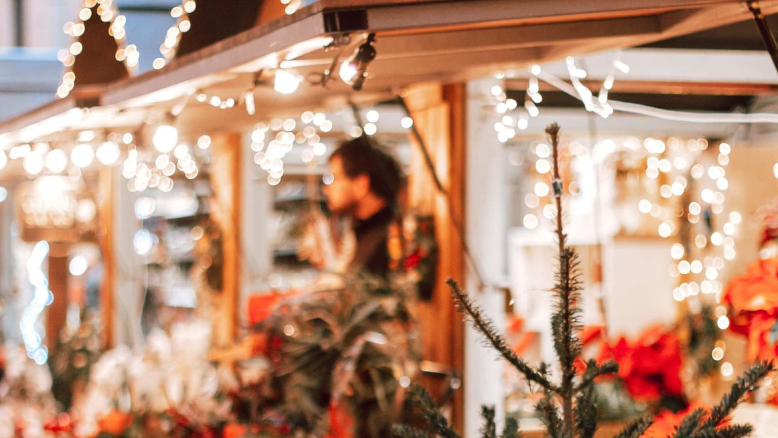 Close-up of a Christmas market stall in Porto decorated with warm lights and festive ornaments