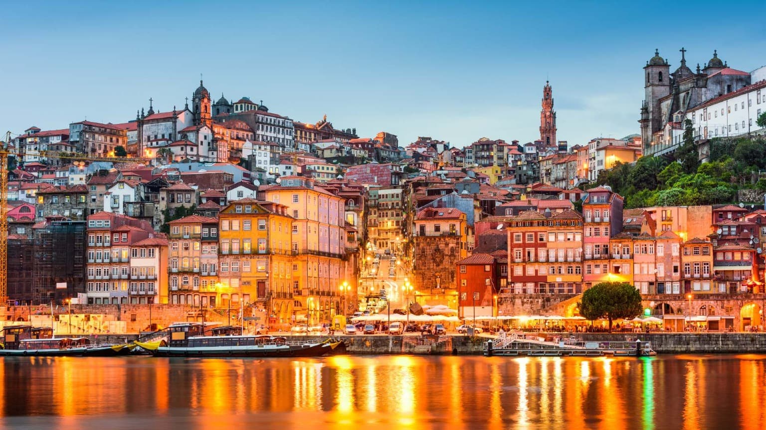 Night view of Porto’s colourful Ribeira district reflected on the Douro River, a stunning setting for New Year’s Eve fireworks
