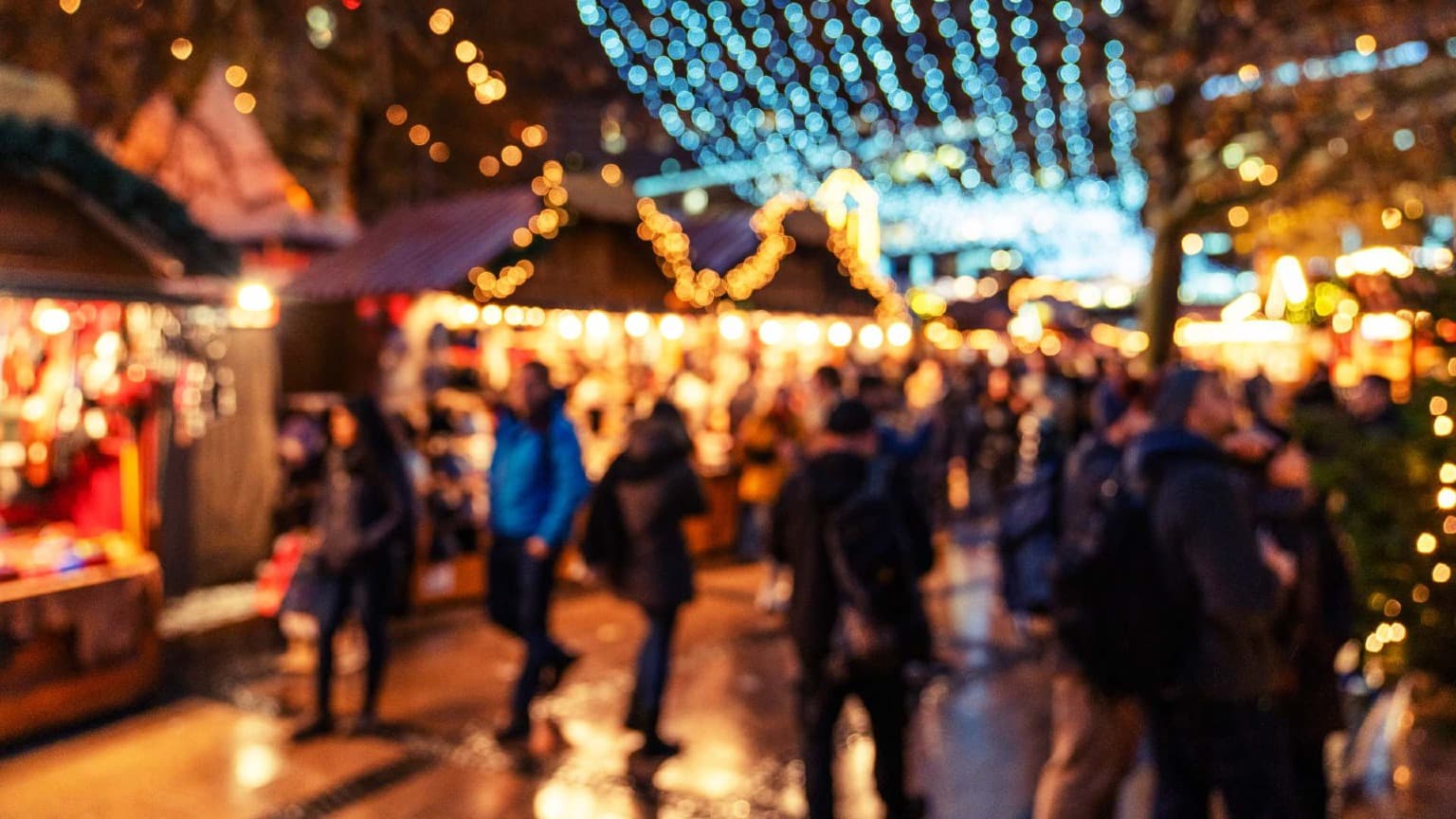 Crowds exploring the illuminated Christmas market at Cordoaria in Porto under glowing festive lights