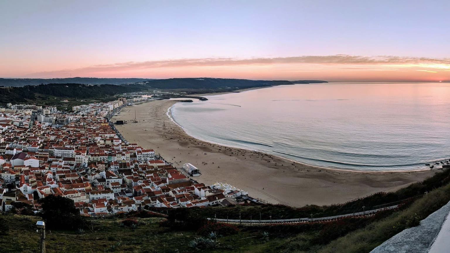 Panoramic sunset view over Nazaré beach and old town taken from the Sítio viewpoint during winter