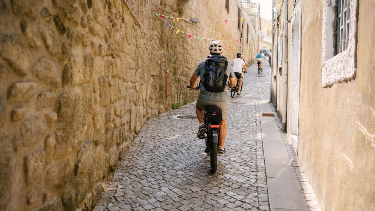 Small group riding electric bikes through the historic streets of Porto during a highlights and history e-bike tour
