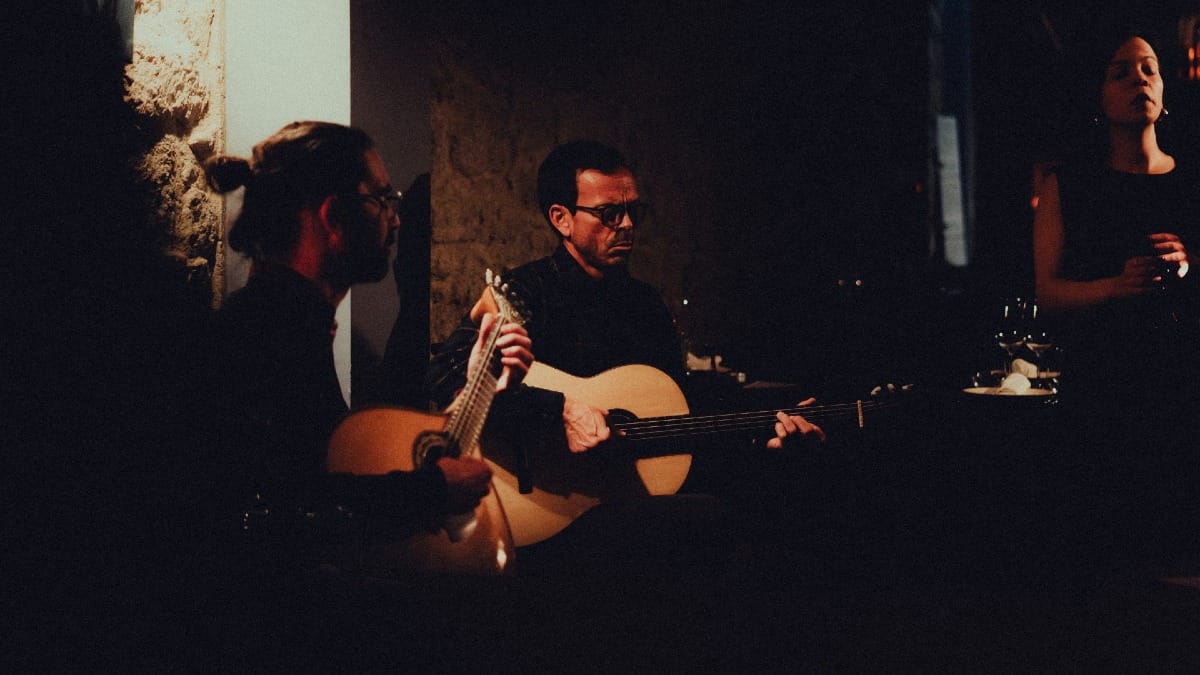 Two Portuguese guitarists performing live as a Fado singer delivers an emotional performance