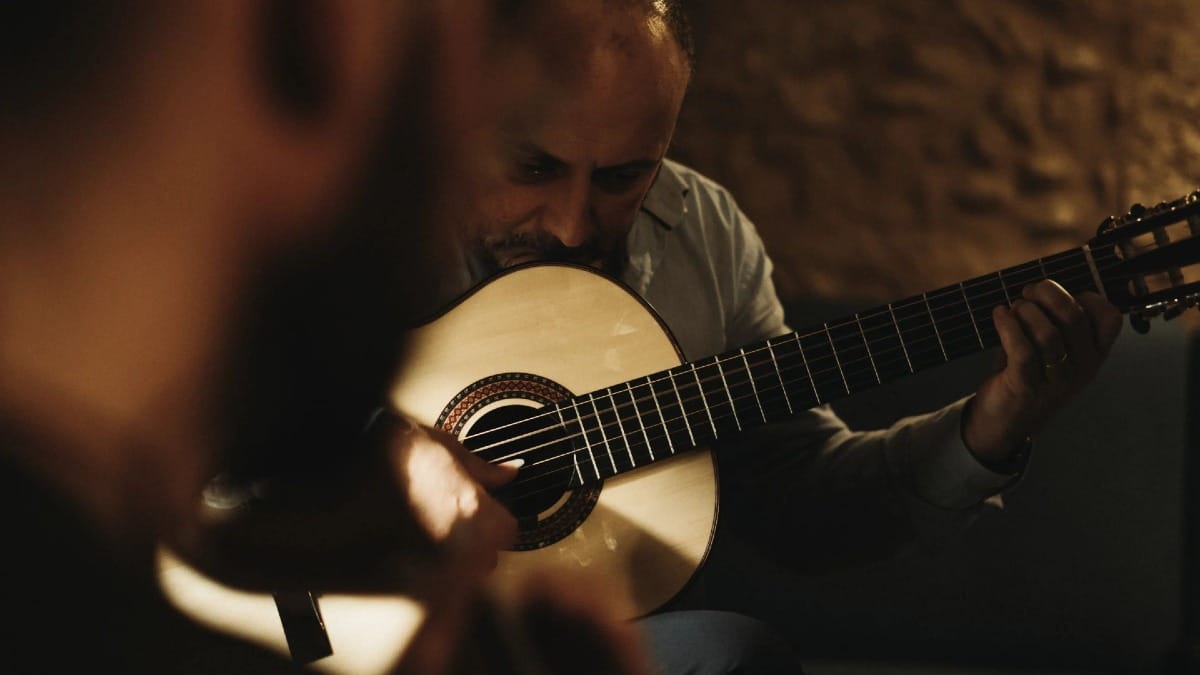 Primer plano del guitarrista clásico durante un espectáculo de Fado en Oporto