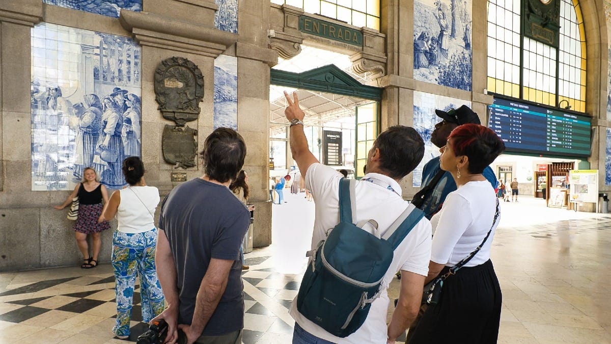 Guia da Cooltour Oporto a explicar os painéis de azulejos na Estação de São Bento durante um food tour cultural no Porto