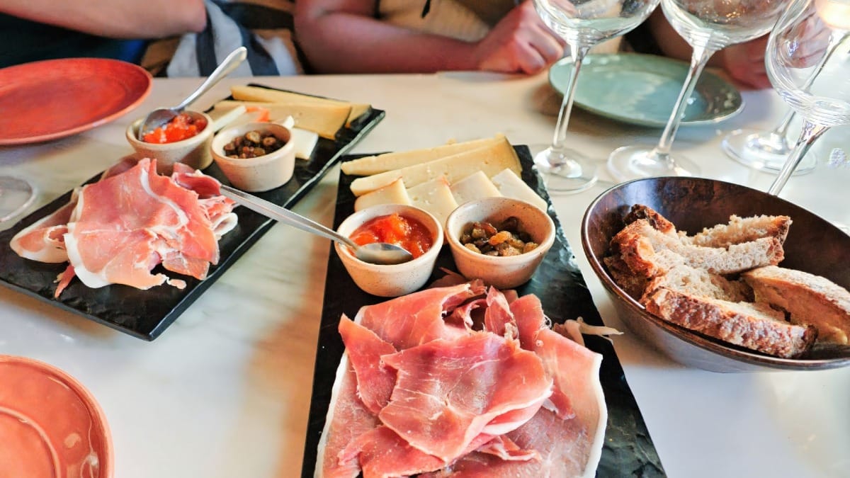 Enchidos, queijos e petiscos tradicionais servidos com pão caseiro durante uma prova de vinhos no Porto