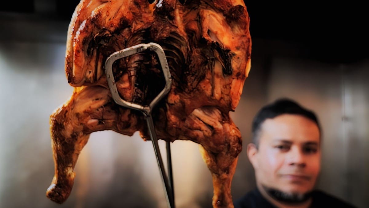 Pollo asado entero recién salido del horno en un restaurante de barbacoa tradicional en el centro de Oporto