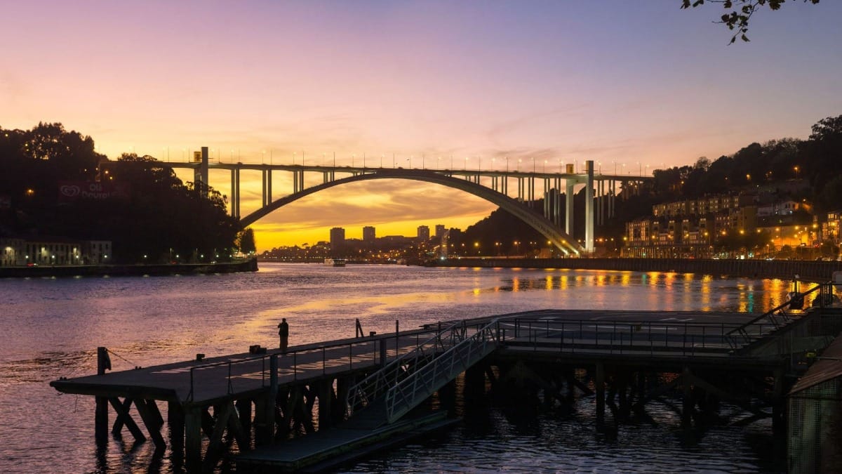 Pôr do sol deslumbrante atrás da Ponte da Arrábida durante o Jantar de Fado e Tour Noturno no Porto com a Cooltour Oporto