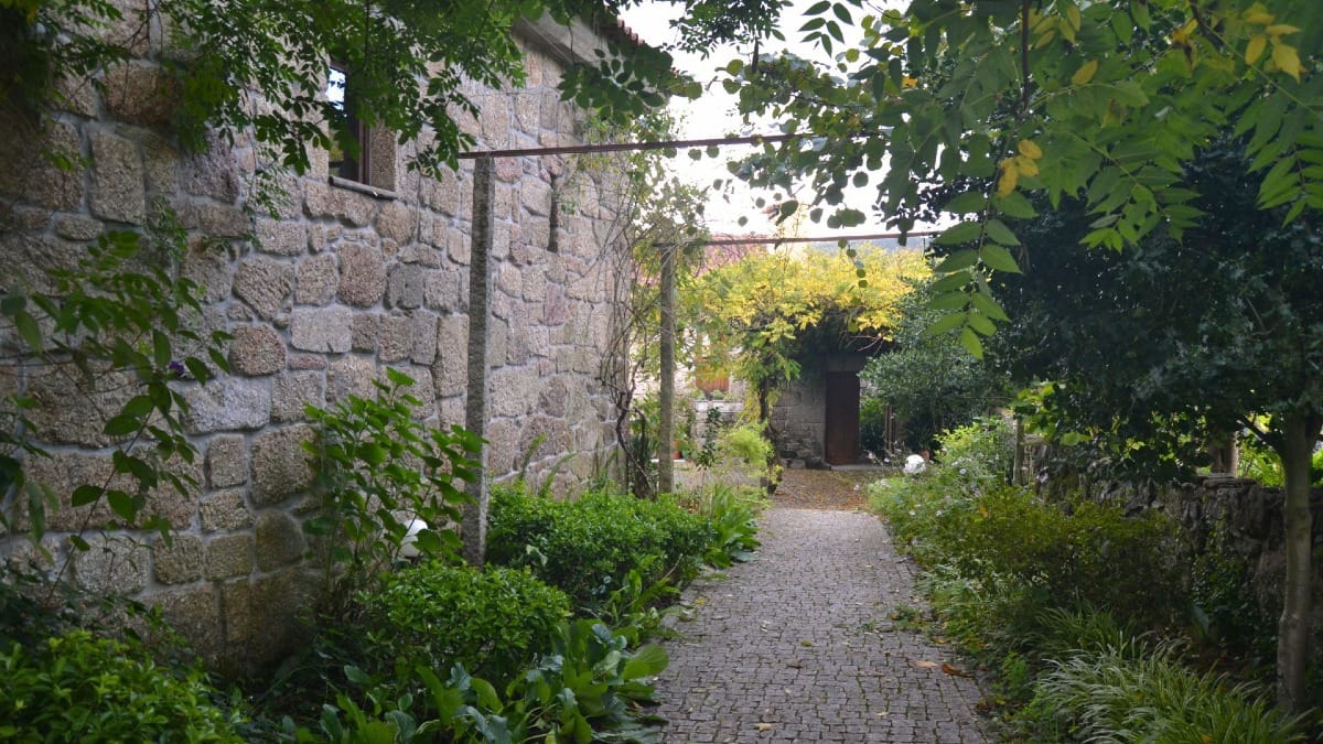Rustic farmhouse exterior surrounded by greenery | Cooltour Oporto