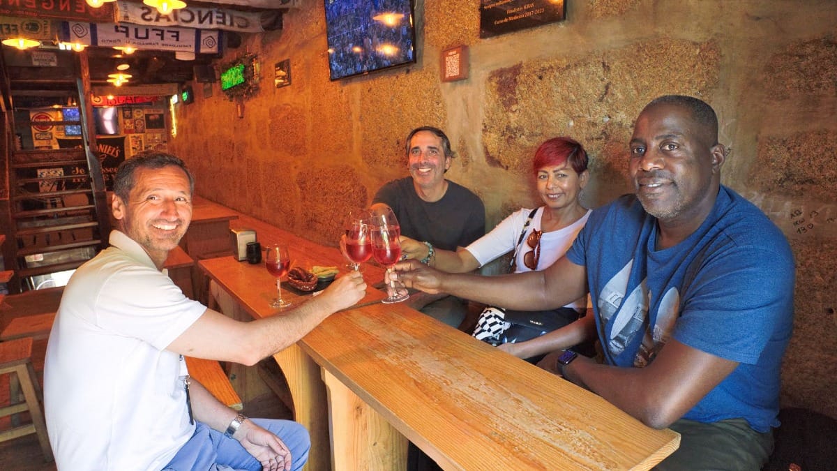 Grupo a brindar com vinho rosé numa taberna do Porto durante um food tour da Cooltour Oporto