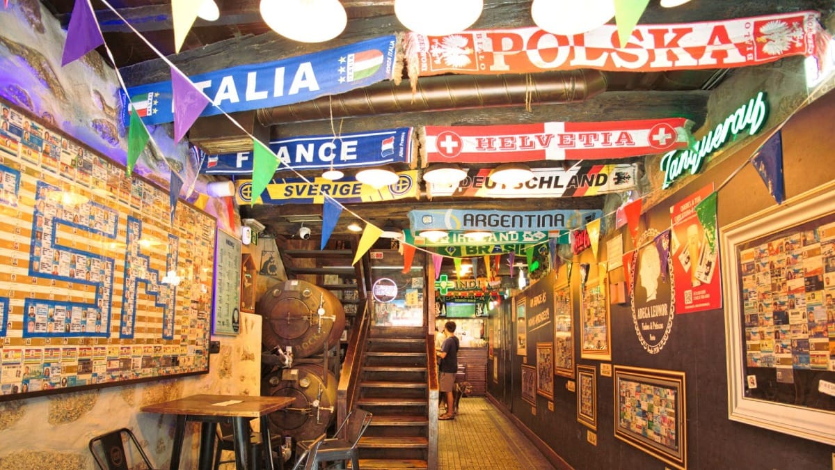 Interior vibrante de una taberna tradicional de Oporto decorada con bufandas de fútbol, parte del itinerario del food tour de Cooltour Oporto