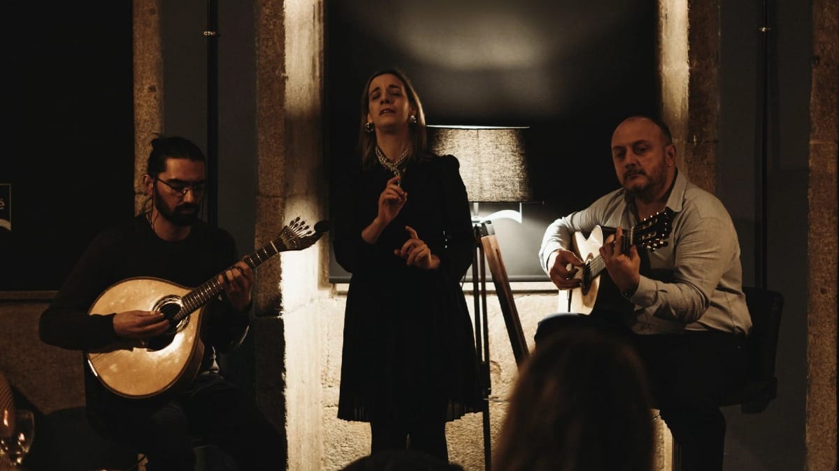 Fado trio performing live in Porto: vocalist, Portuguese guitar, and classical guitar musicians
