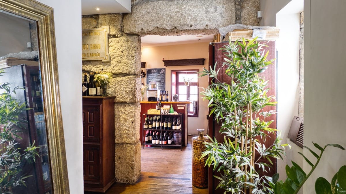 Intérieur chaleureux d’un bar à vin caché à Porto avec des bouteilles de vins portugais et une déco rustique