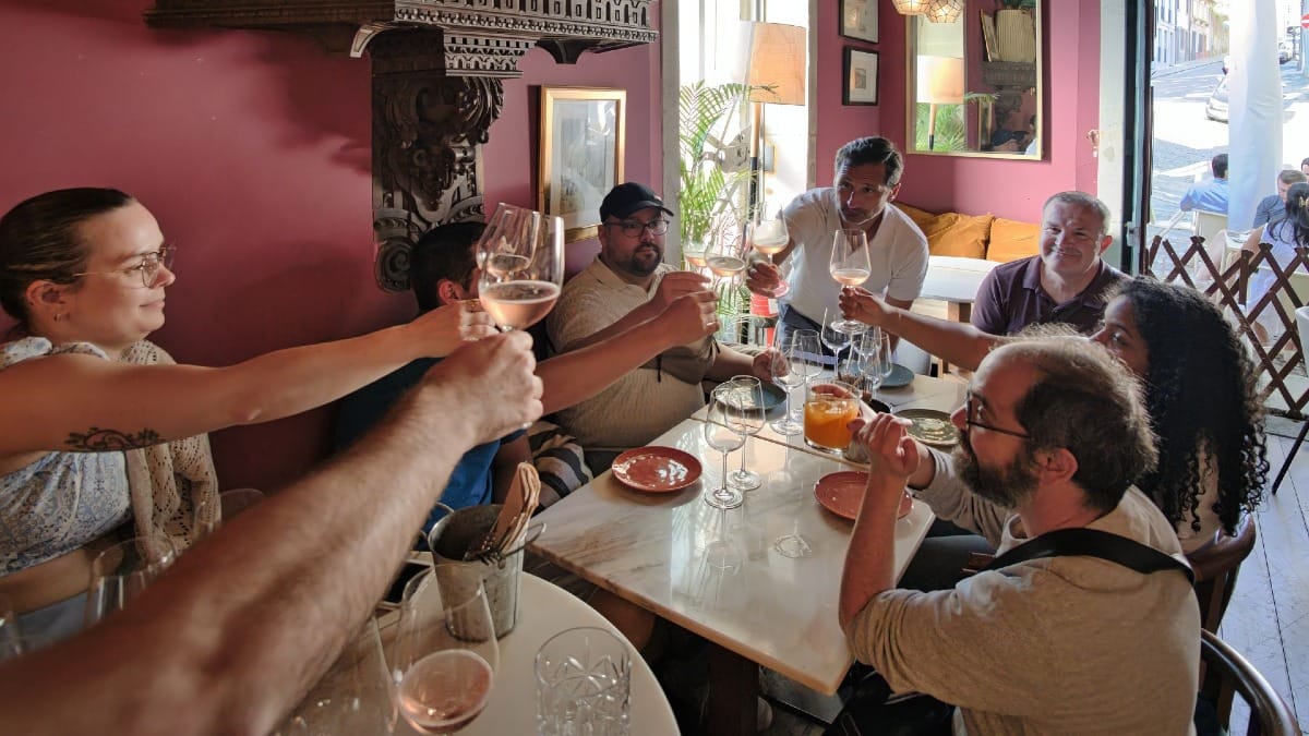 Small group toasting with wine glasses during a cozy wine tasting and Fado show experience in Porto by Cooltour Oporto