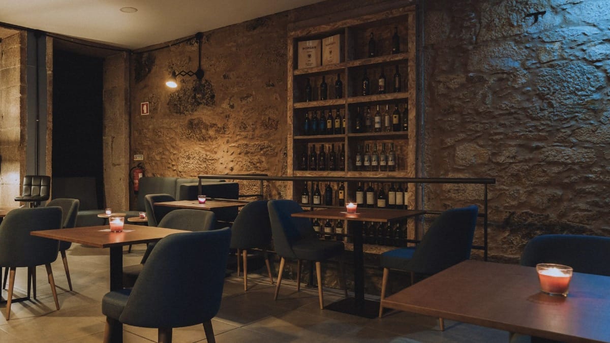 Bar de vinos íntimo en Oporto con luz tenue y ambiente acogedor para espectáculos de Fado por Cooltour Oporto