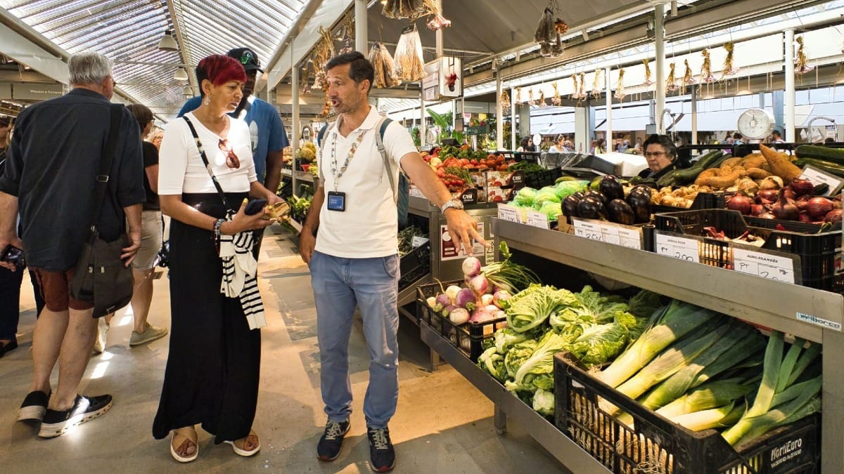 Guía local de Cooltour Oporto explicando productos portugueses tradicionales en el mercado municipal de Oporto