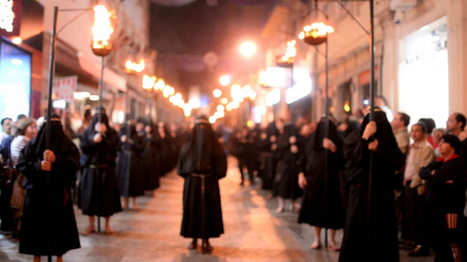 Ecce Homo procession in Braga during Holy Week with participants dressed in traditional black robes carrying torches
