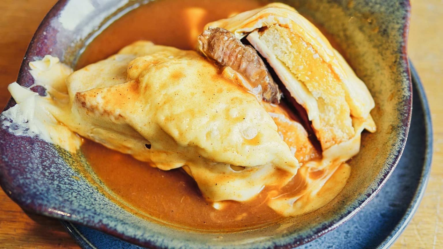 Traditional Francesinha sandwich in Porto served with melted cheese and beer sauce