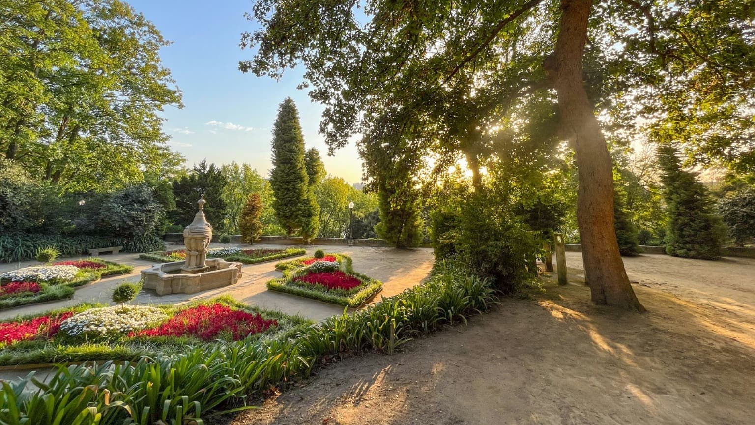 Imagem de um jardim florido com uma fonte nos Jardins do Palácio de Cristal