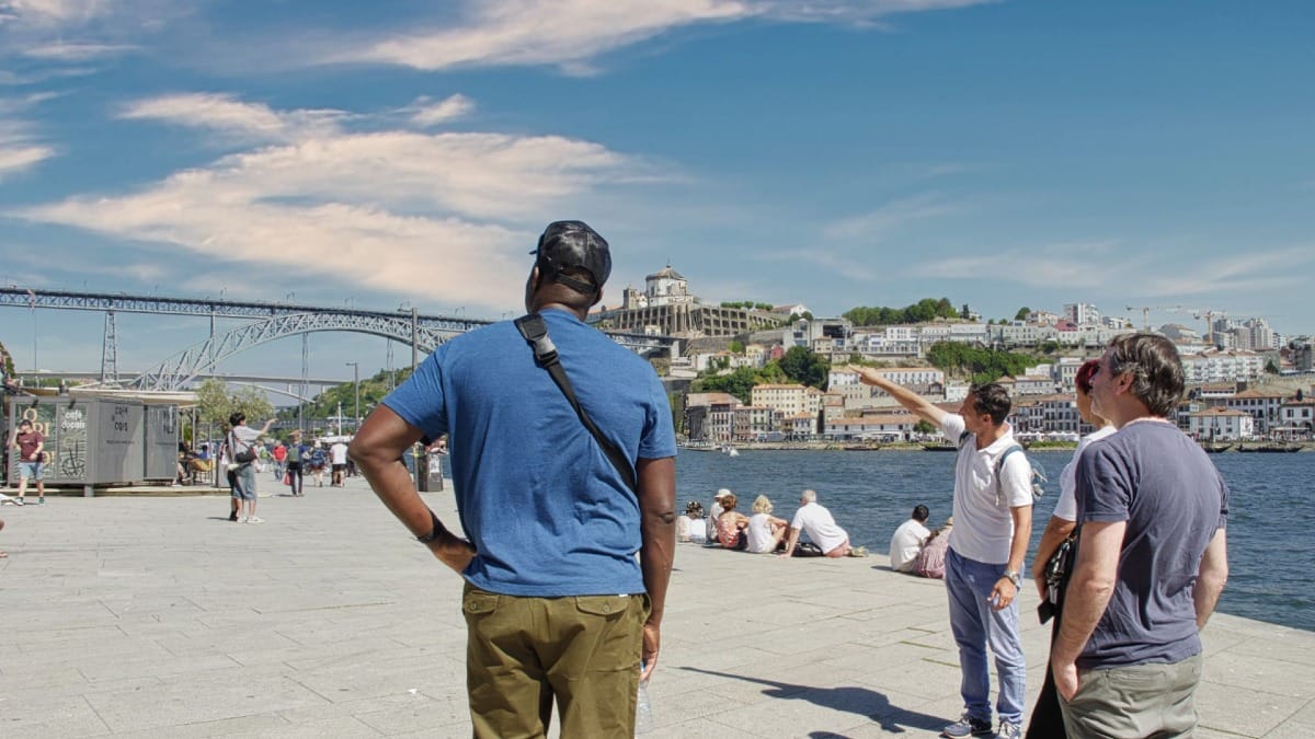 Guia da Cooltour Oporto a explicar a história da Ribeira junto ao rio Douro com vistas deslumbrantes